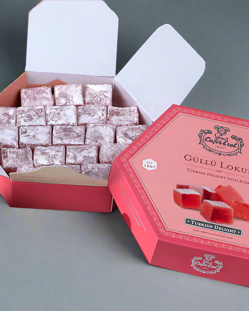 A box of rose-flavored Turkish delight cubes in a hexagonal shape, with the branding and product details visible on the packaging.