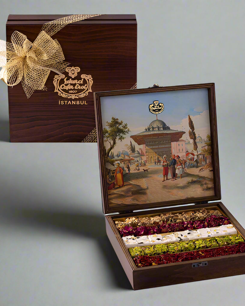 A wooden box with a painted scene of Istanbul on the lid, containing special Turkish delight. The box is adorned with a golden bow and is open, displaying the delicately arranged sweets.