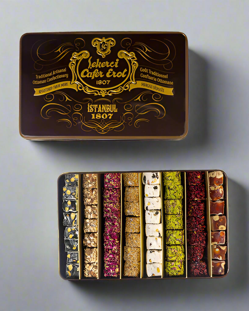 A tin box of Mixed Roll Turkish Delight with rose, lemon, and pistachio flavors, featuring a decorative cover with gold details and the brand name Çekerci Cafer Erol.