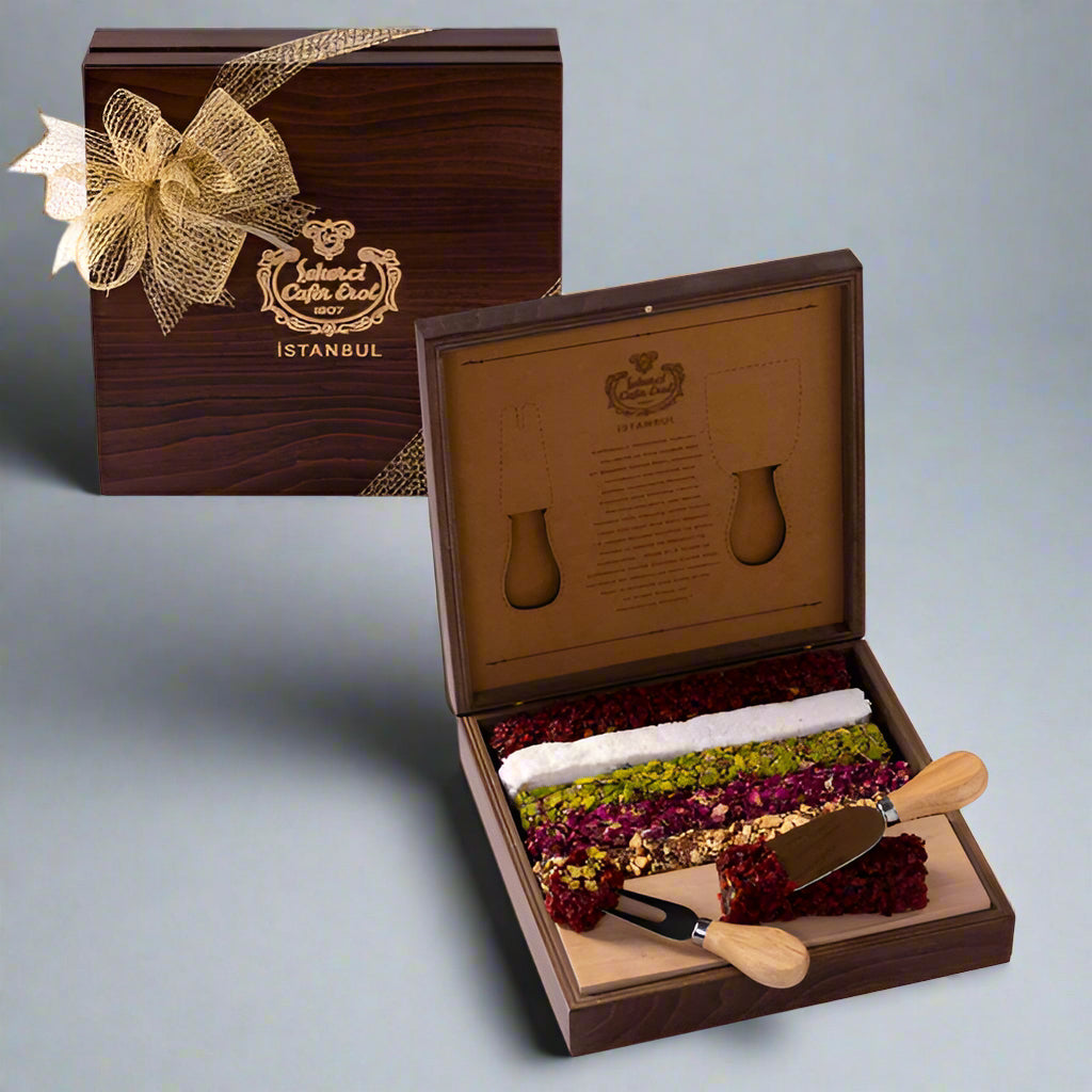 A wooden box of Special Turkish Delight with a knife, the box is open showing various snacks inside and a pair of utensils lie on the side.